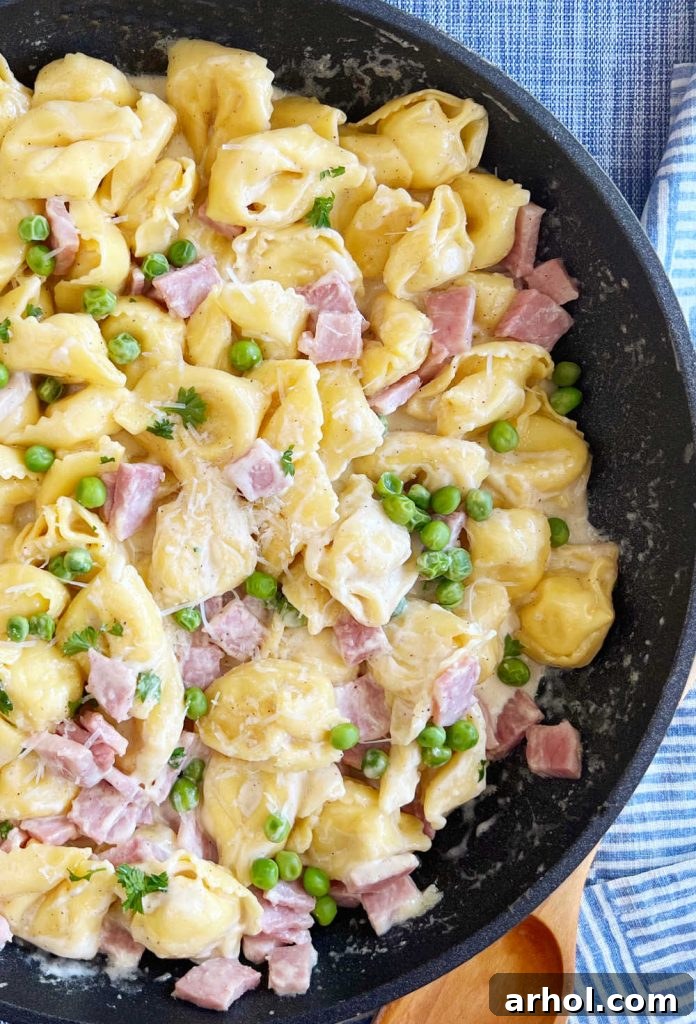 Completed Cheese Tortellini with Ham and Peas, served in a skillet, ready to eat.