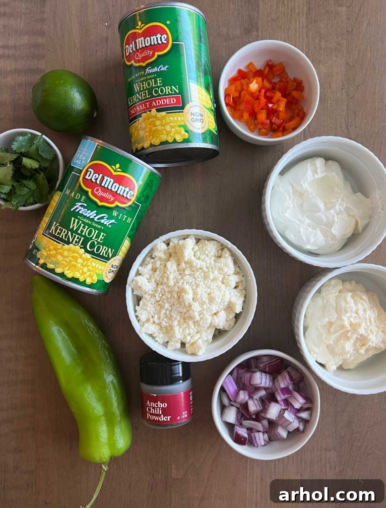 An array of fresh and pantry ingredients laid out: canned corn, mayonnaise, sour cream, fresh cilantro, zesty lime, crumbled Cotija cheese, vibrant bell peppers, diced red onion, and smoky chili powder, ready for Mexican street corn salad preparation.