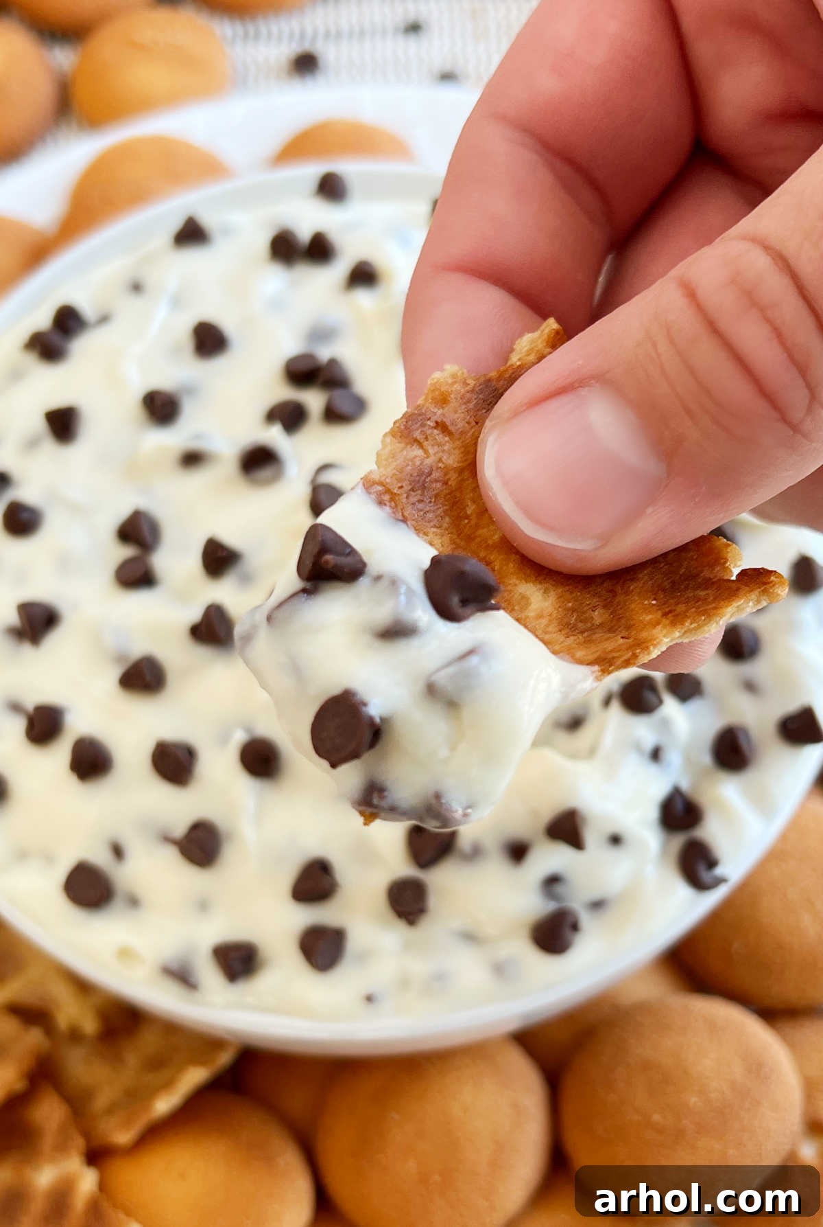 hand holding cannoli dip on waffle cone piece