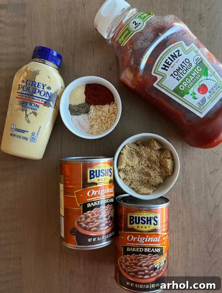 A delightful arrangement of raw ingredients for baked beans: canned baked beans, a bowl of brown sugar, ketchup, Dijon mustard, and a small dish of seasonings.