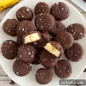 Frozen chocolate banana bites with flaked sea salt on a plate, presented beautifully.