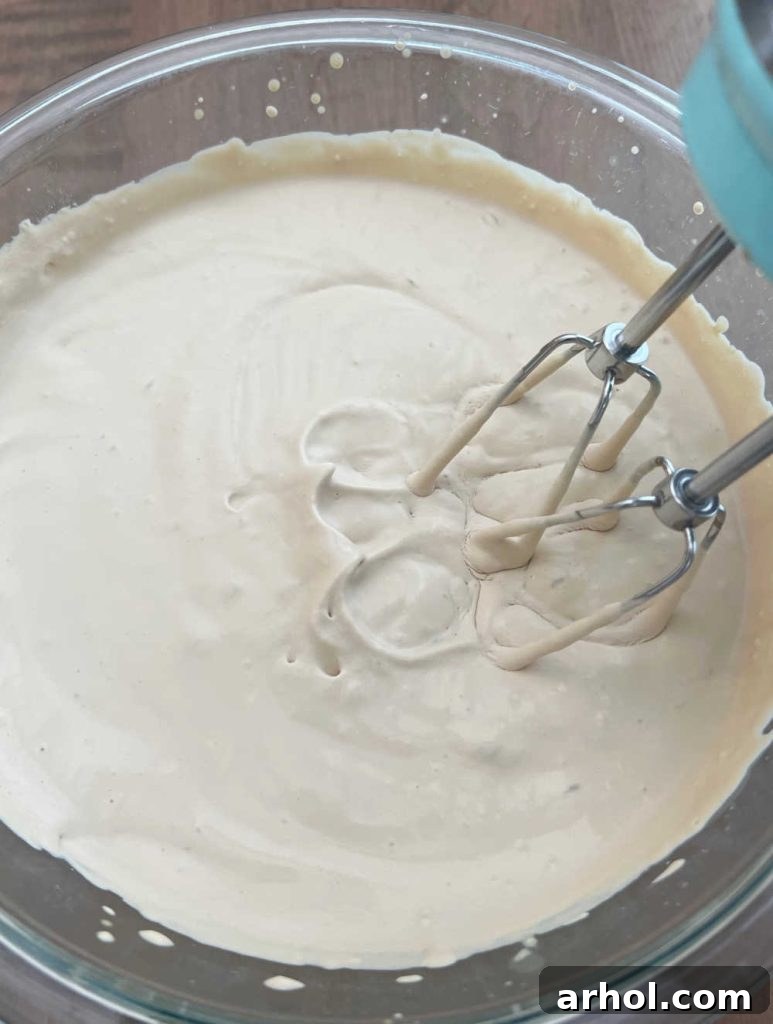 Beat heavy whipping cream with an electric mixer in a mixing bowl until stiff peaks form.