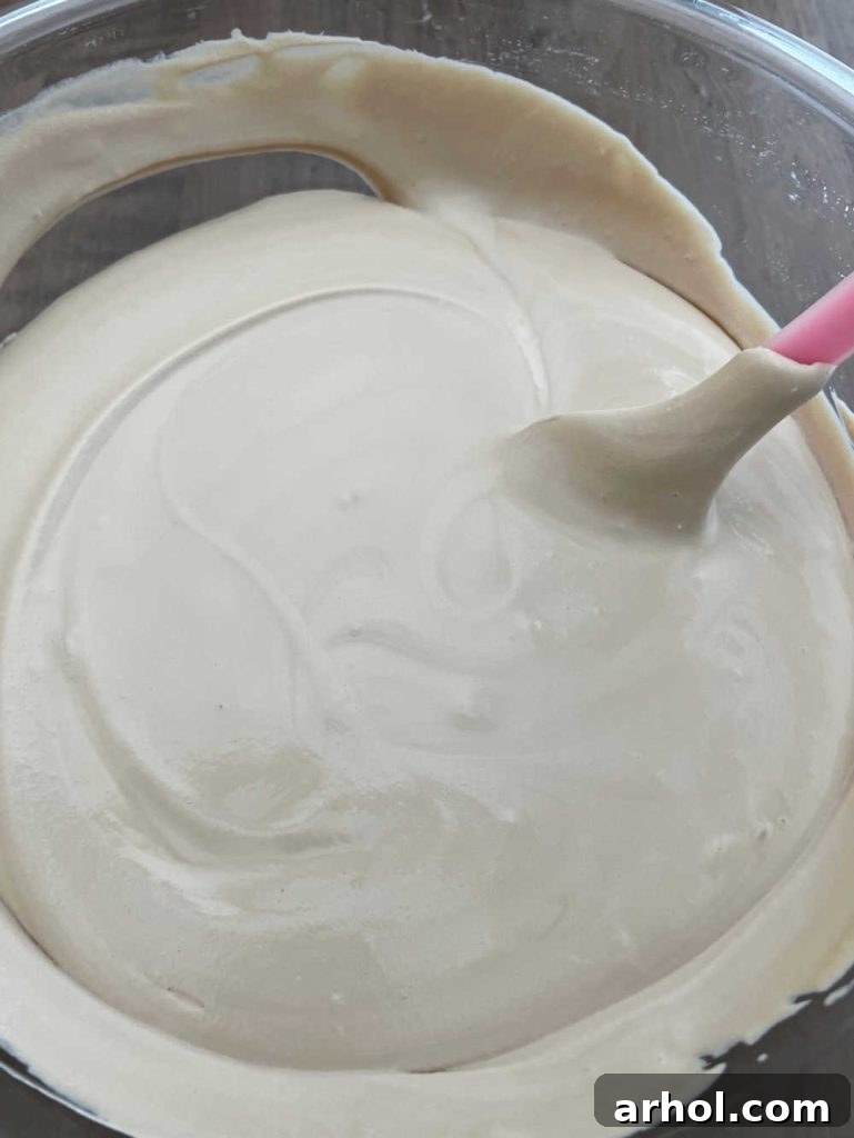 Gently fold whipped cream mixture into sweetened condensed milk with a spatula.