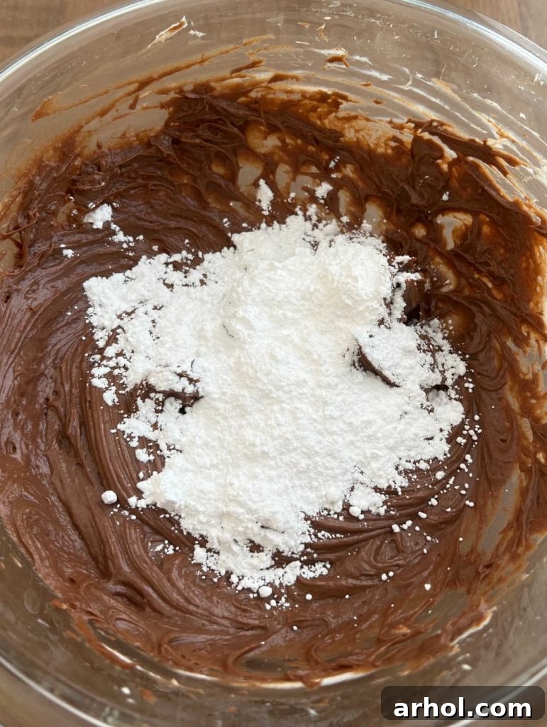 A mixing bowl displaying the perfectly smooth blend of Nutella, cream cheese, and powdered sugar, forming the rich and sweet base for the creamy cheesecake dip.