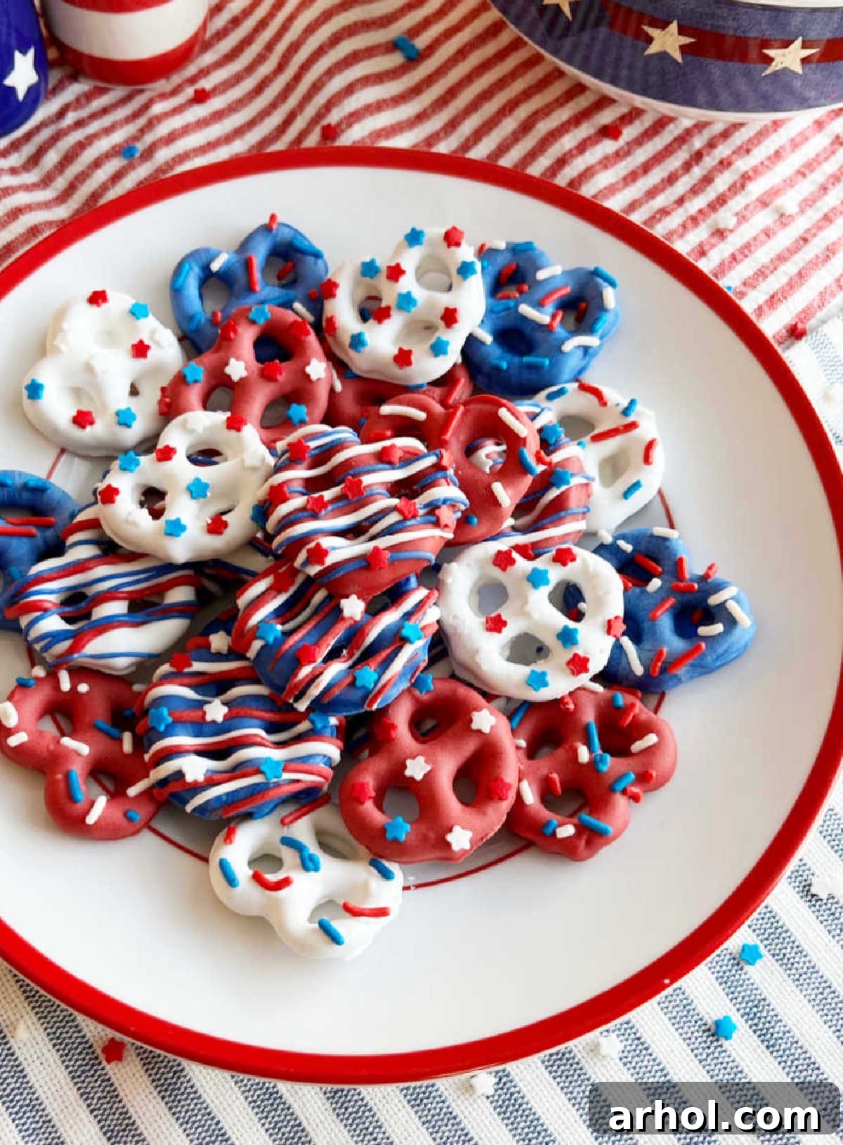 Red, White, and Blue chocolate-covered pretzels with patriotic sprinkles on a Fourth of July table, symbolizing festive celebration.