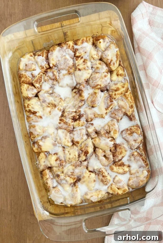 cinnamon roll breakfast bake with cream cheese frosting in baking dish