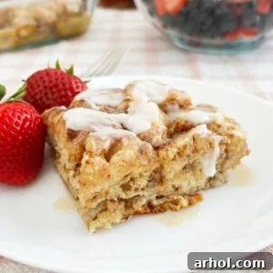 cinnamon roll casserole with cream cheese frosting and maple syrup on plate