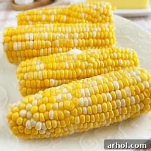 Microwaved corn on the cob with melted butter on a platter.