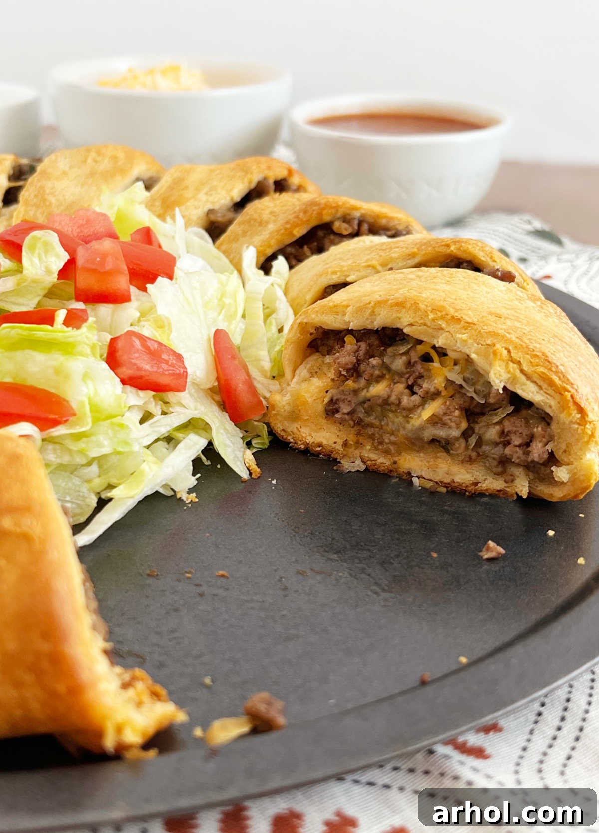 A slice of baked taco ring, revealing the rich hamburger meat and melted cheese filling, resting on a serving plate.