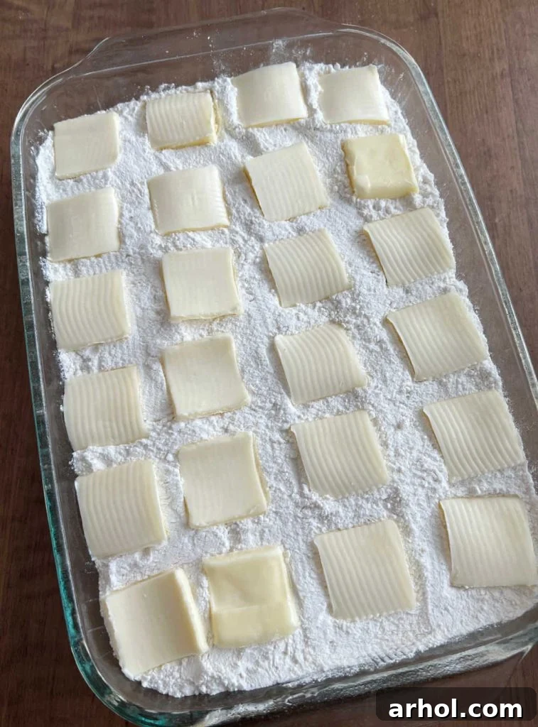 Effortless Caramel Apple Dump Cake 7 Arranging thin slices of butter in neat rows over the dry cake mix layer.