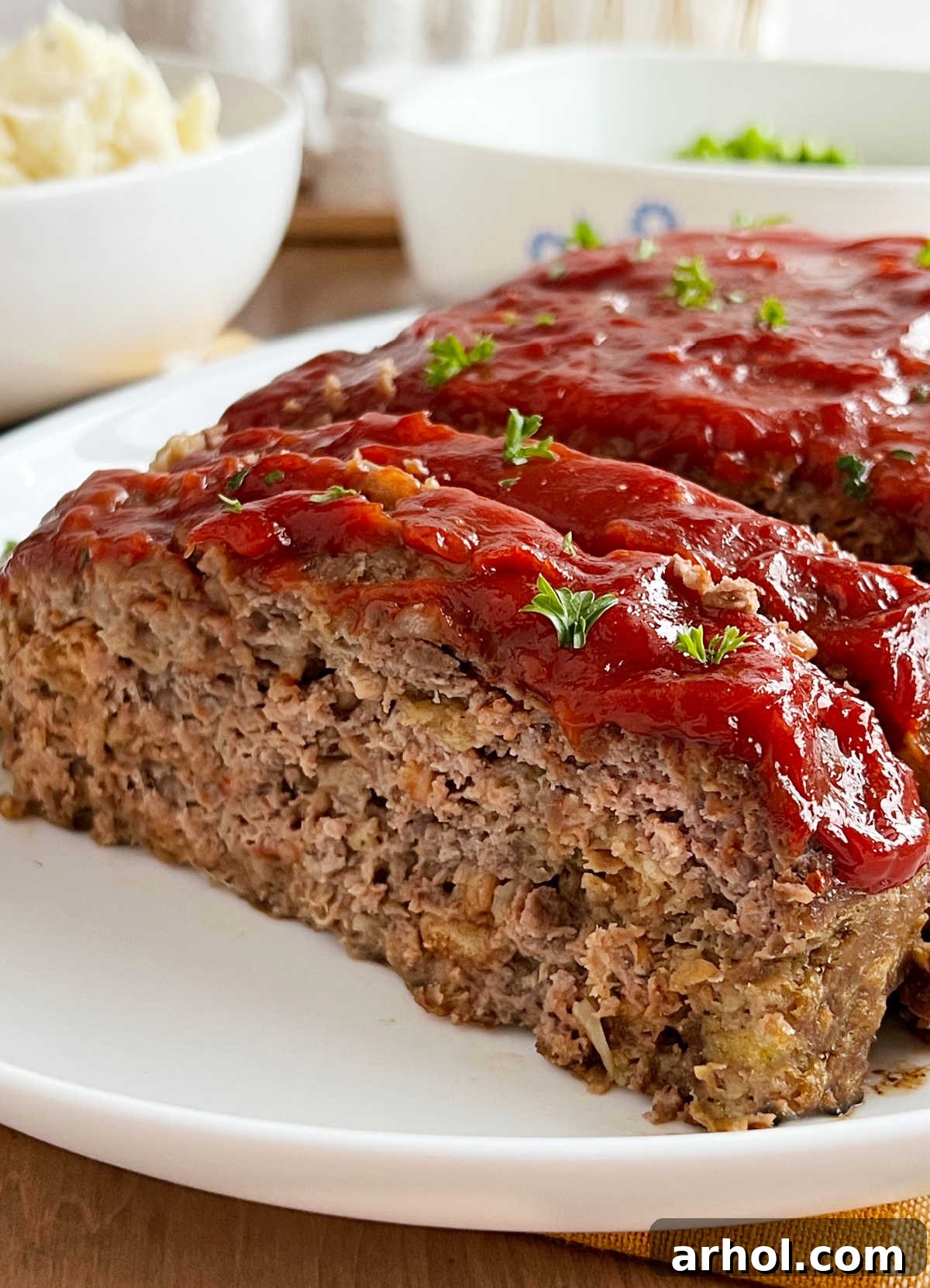 meatloaf with stove top stuffing and ketchup glaze sliced on a platter.
