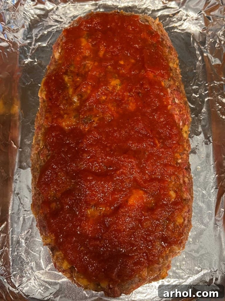 meatloaf topped with marinara sauce in baking pan.