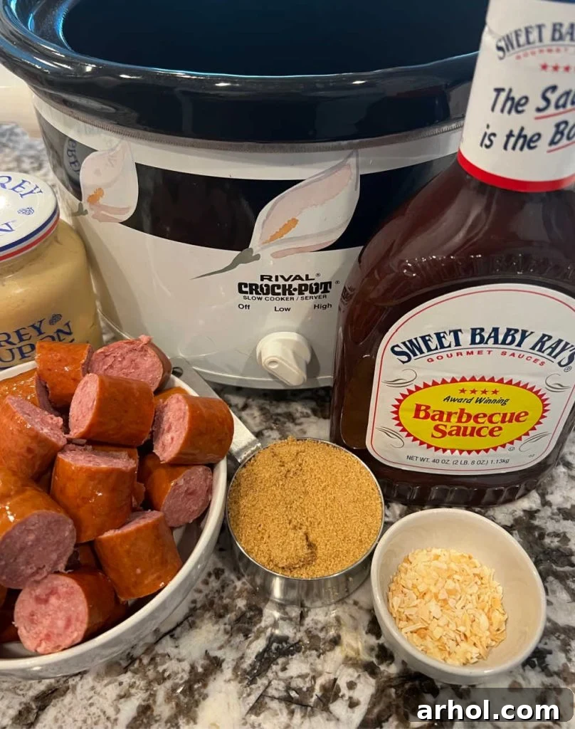 An organized display of key ingredients for Slow Cooker Kielbasa Bites, including sliced kielbasa, a jar of Dijon mustard, brown sugar, a bottle of BBQ sauce, and dried minced onions, set beside a classic slow cooker.