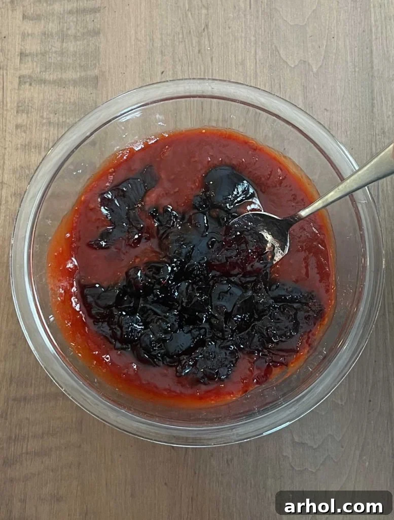 mix grape jelly with chili sauce in small bowl with spoon.