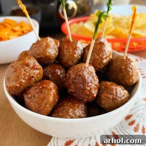 crockpot grape jelly meatballs with party toothpicks in serving bowl.