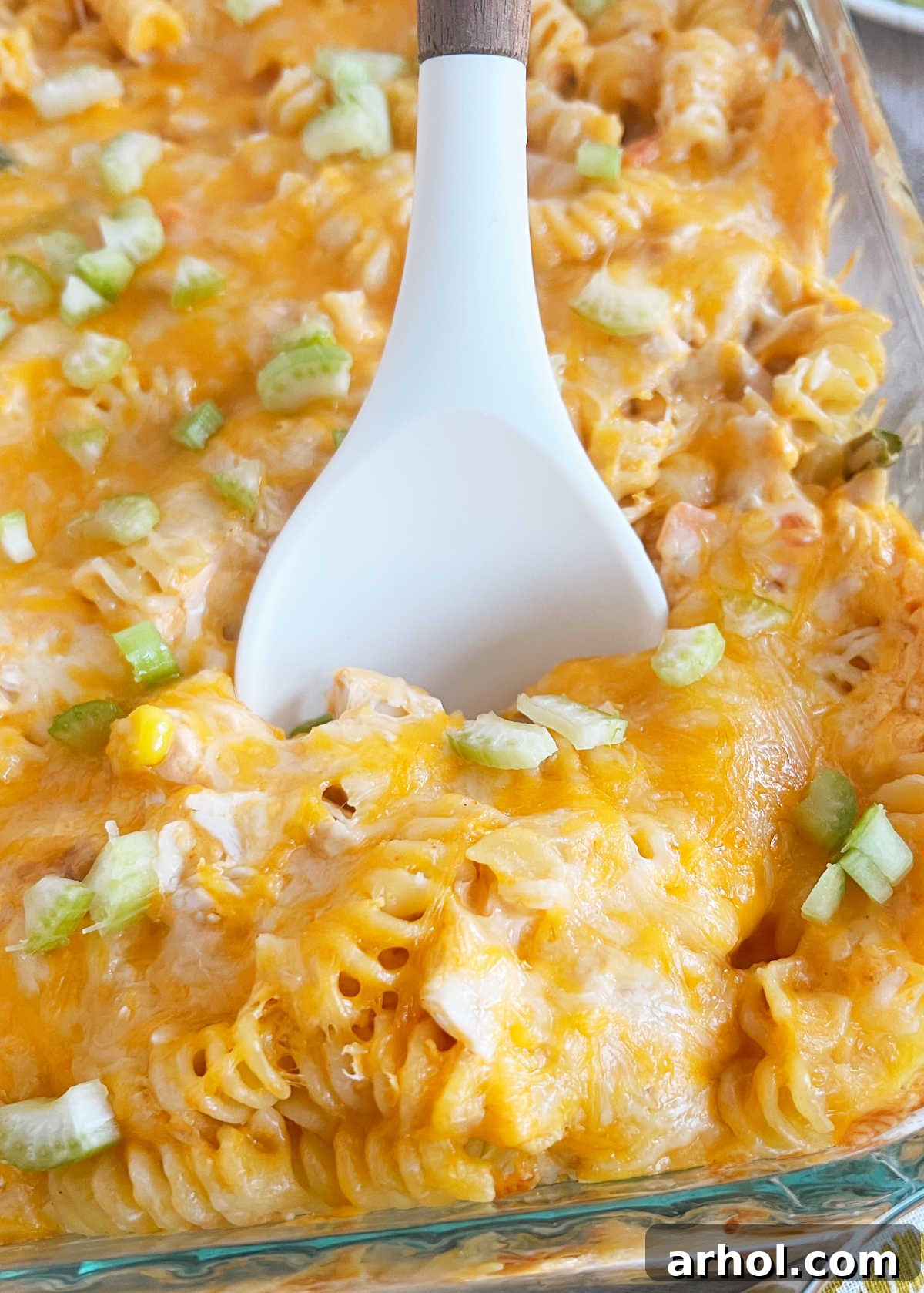 Close-up of creamy, cheesy Buffalo Chicken Pasta Bake served on a white spoon, showing the rich texture and ingredients.