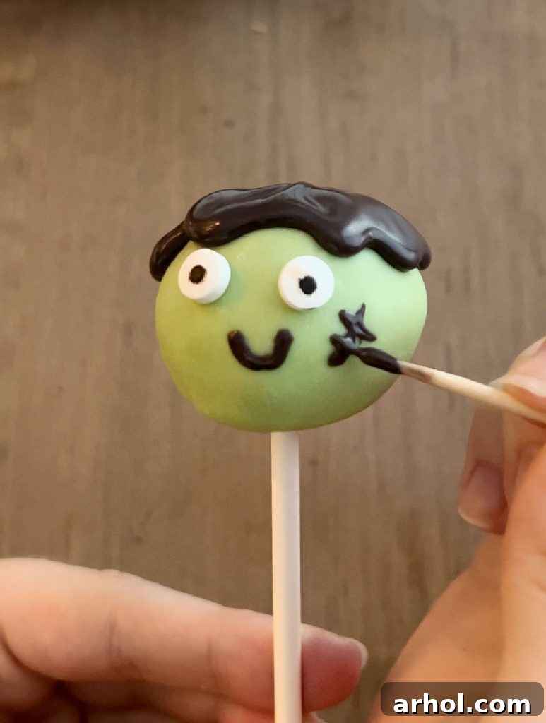 Steps for decorating a Frankenstein cake pop: green candy coating, candy eyes, and black chocolate piped for hair and face details.