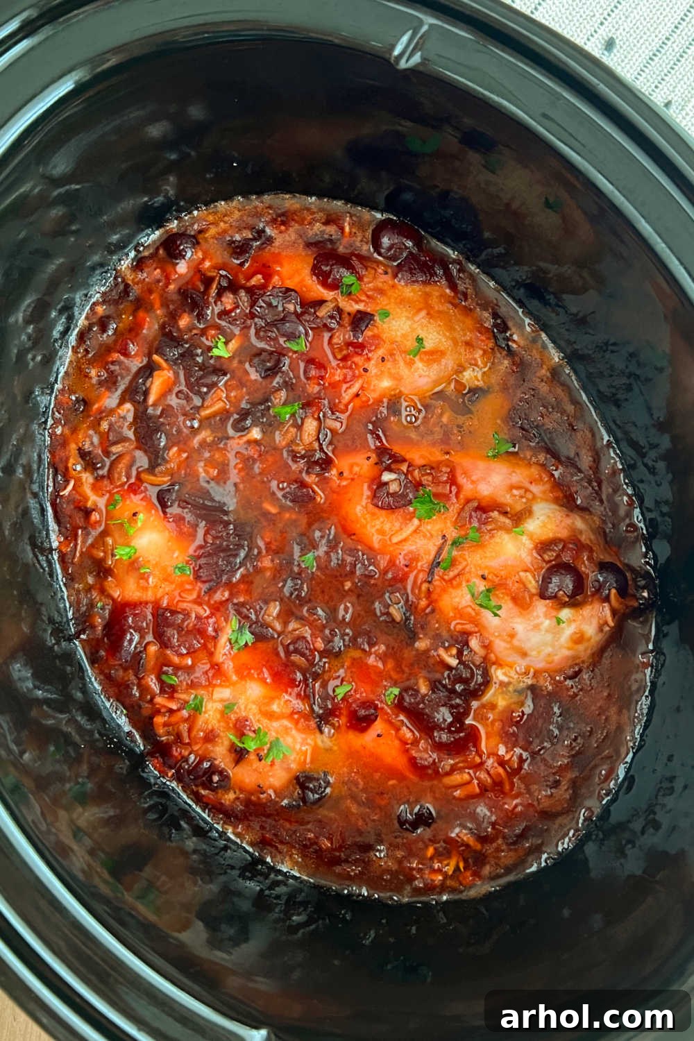 Succulent slow cooker cranberry chicken with whole berries and a rich sauce, ready to serve from the crock pot.