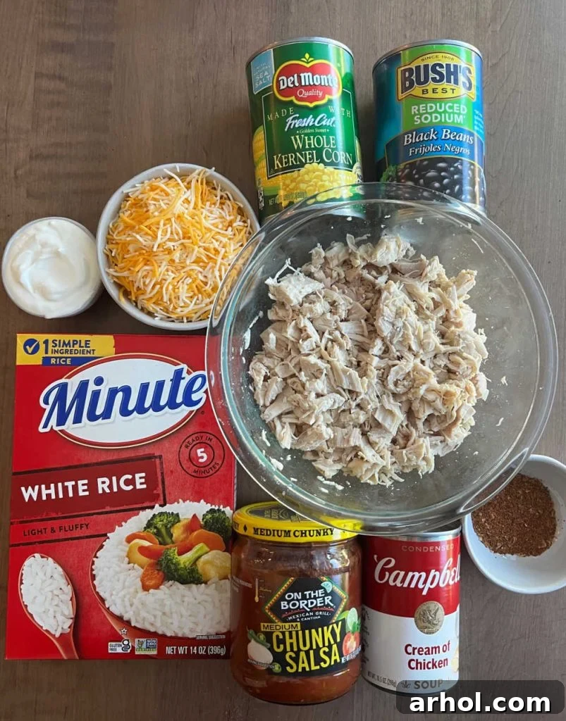 Individual ingredients laid out: cooked chicken, instant rice, sour cream, shredded cheese, corn, black beans, salsa, cream of chicken soup, and taco seasoning.
