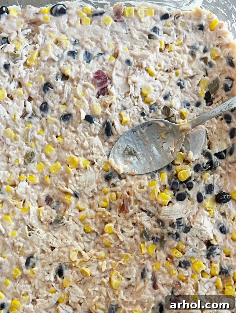 Spreading the chicken and rice mixture evenly into a baking dish.
