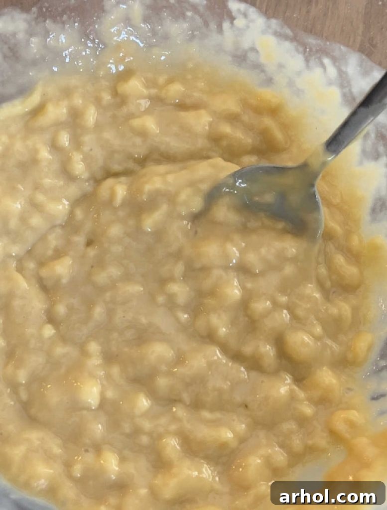 A mixing bowl shows cream of chicken soup, milk, and soy sauce being whisked together into a smooth, creamy base for the casserole.