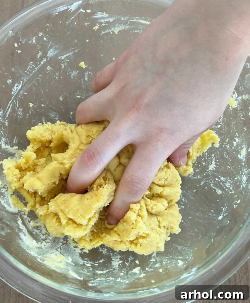 Mixing crumbled cake and frosting together in a large mixing bowl to form the cake pop dough.