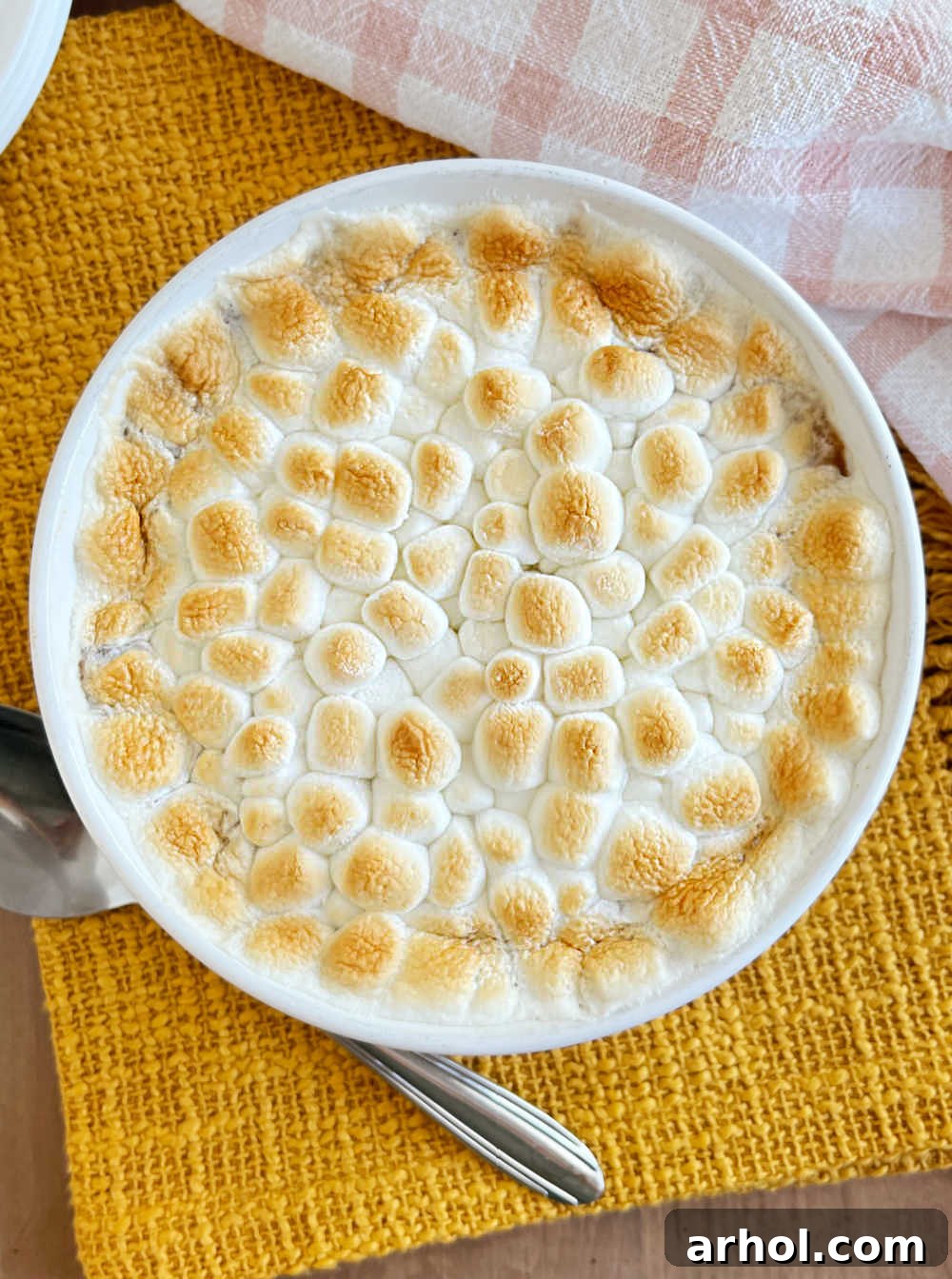 baked sweet potato casserole with marshmallows on table.