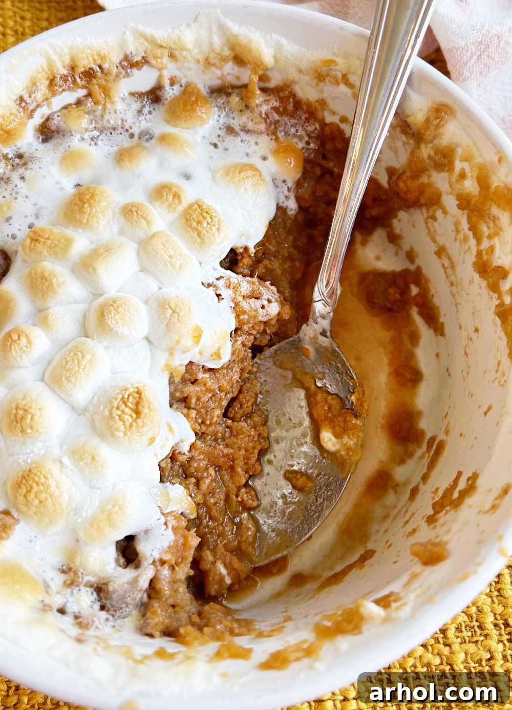 serving spoon in half empty casserole dish.