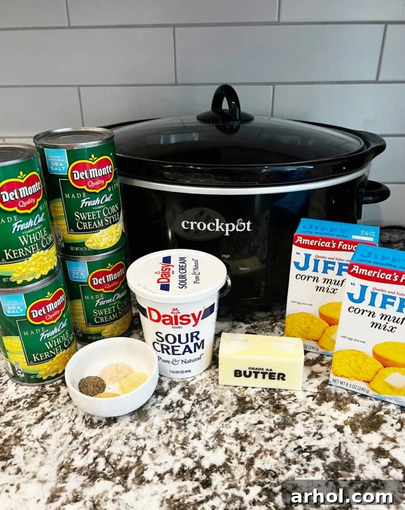 Essential ingredients for Jiffy Corn Casserole: cream style corn, whole kernel corn, sour cream, butter, Jiffy muffin mix, and seasonings.