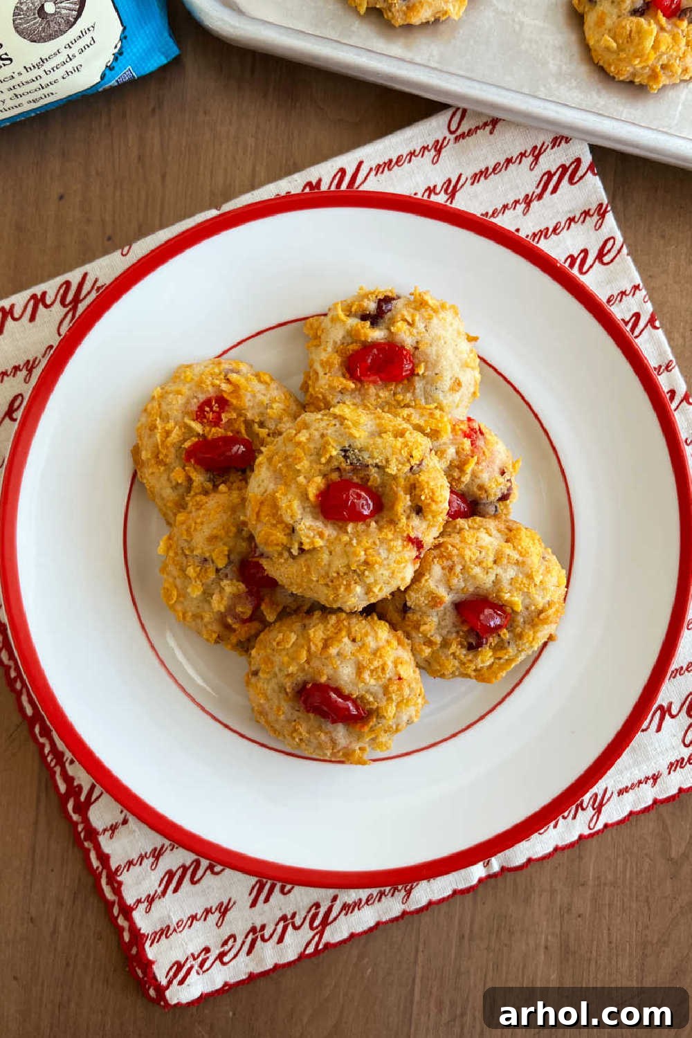 A stack of perfectly baked cherry wink cookies arranged on a festive red and white holiday plate, ready for serving.