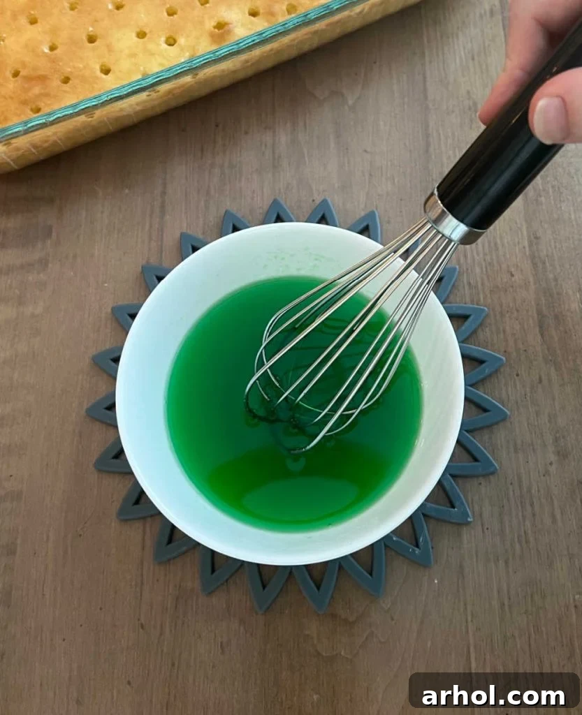 Mixing lime Jell-O powder with hot water in a small bowl until dissolved.