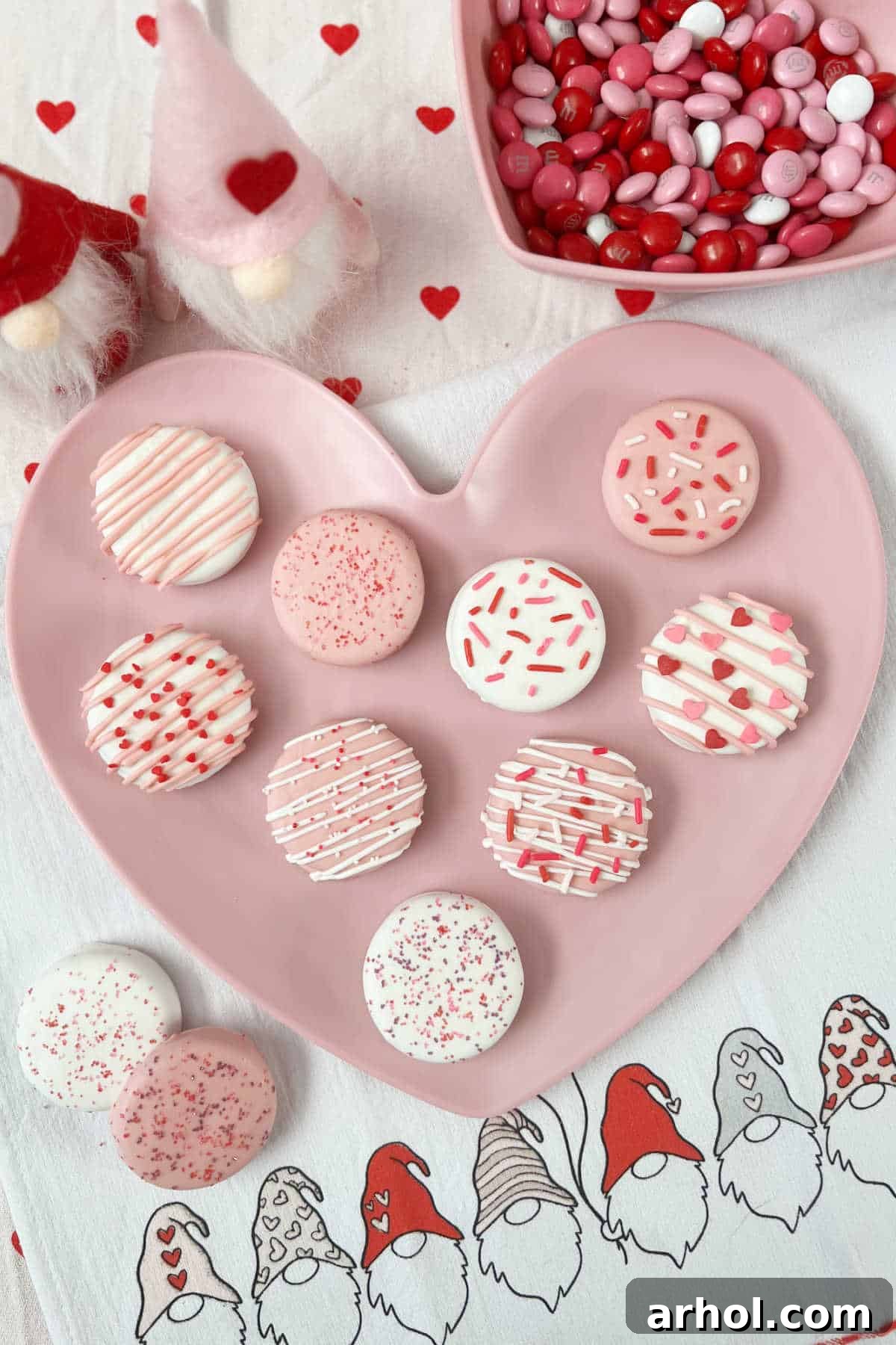 Irresistible White Chocolate Covered Oreos 2 Beautifully decorated white chocolate covered Oreos for Valentine's Day on a heart-shaped plate.