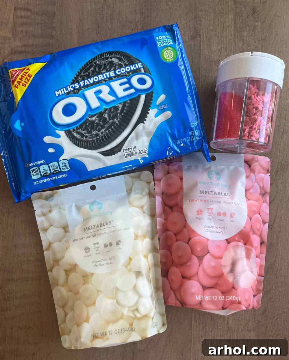 Irresistible White Chocolate Covered Oreos 3 A flat lay showing a package of Oreo cookies, white and pink candy melts, and assorted sprinkles, ready for decoration.