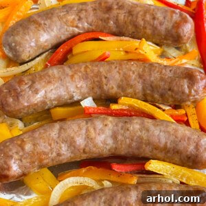 Baked Italian sausage, peppers, and onions on a sheet pan.