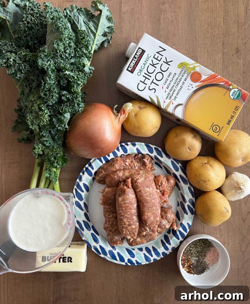 A collection of fresh ingredients for Zuppa Toscana soup: Italian sausage, chicken stock, onion, potatoes, butter, heavy cream, kale, and various spices.