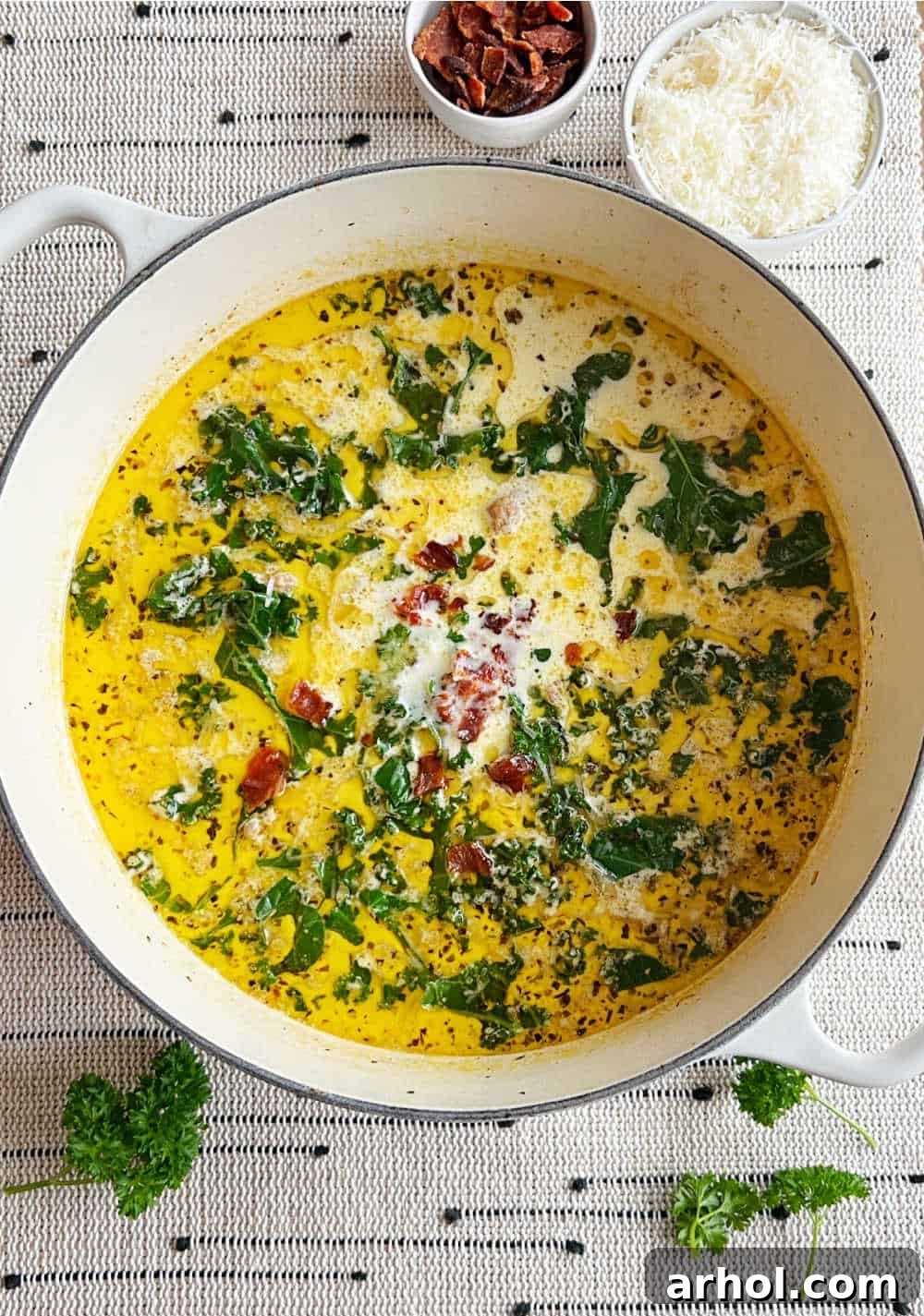 A large white Dutch oven filled with rich, creamy Zuppa Toscana soup, ready to serve.