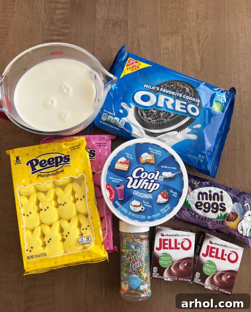 Collection of Easter Dirt Cup ingredients including Peeps bunnies, milk, Oreos, Cool Whip, mini eggs, instant pudding mix, and sprinkles.