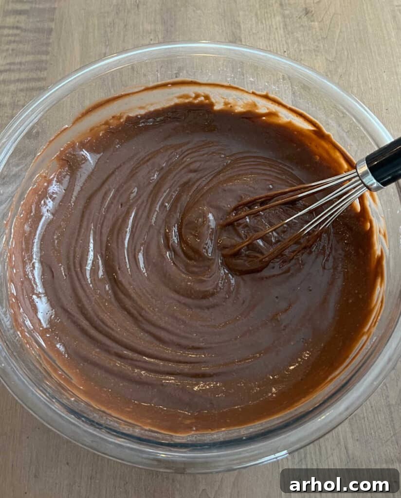 Whisking chocolate instant pudding mix and milk in a large mixing bowl until smooth and thickened.