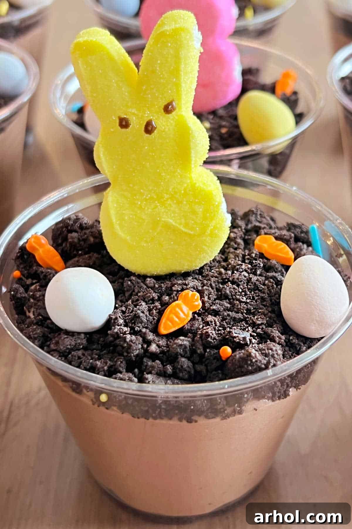Yellow Peeps bunny with candy carrots and mini eggs in an Easter Dirt Cup, perfectly decorated.