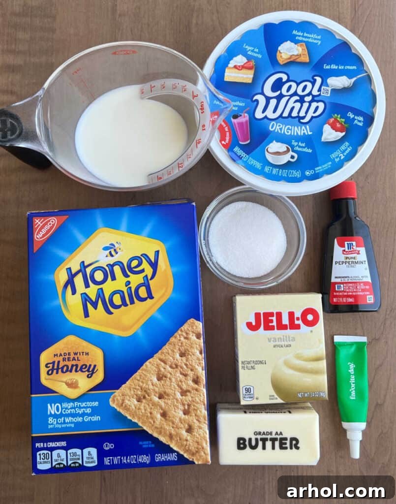 A flat lay photograph showcasing all the simple ingredients required for the shamrock pie: milk, Cool Whip, sugar, instant vanilla pudding mix, peppermint extract, green food coloring, butter, and graham crackers.