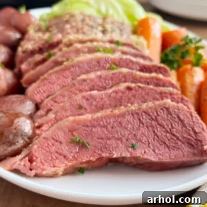sliced crock pot corned beef with cabbage, carrots and potatoes on platter,