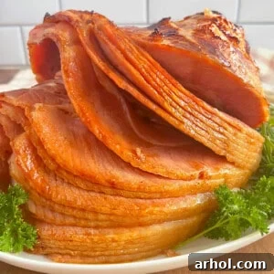 spiral cut baked ham with Dr Pepper glaze on a platter with parsley.