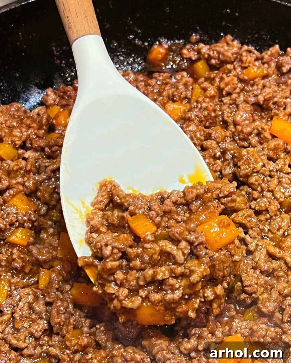 sloppy joes meat on spoon in skillet.