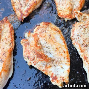 Grilled chicken breasts on Blackstone griddle, golden brown and juicy.