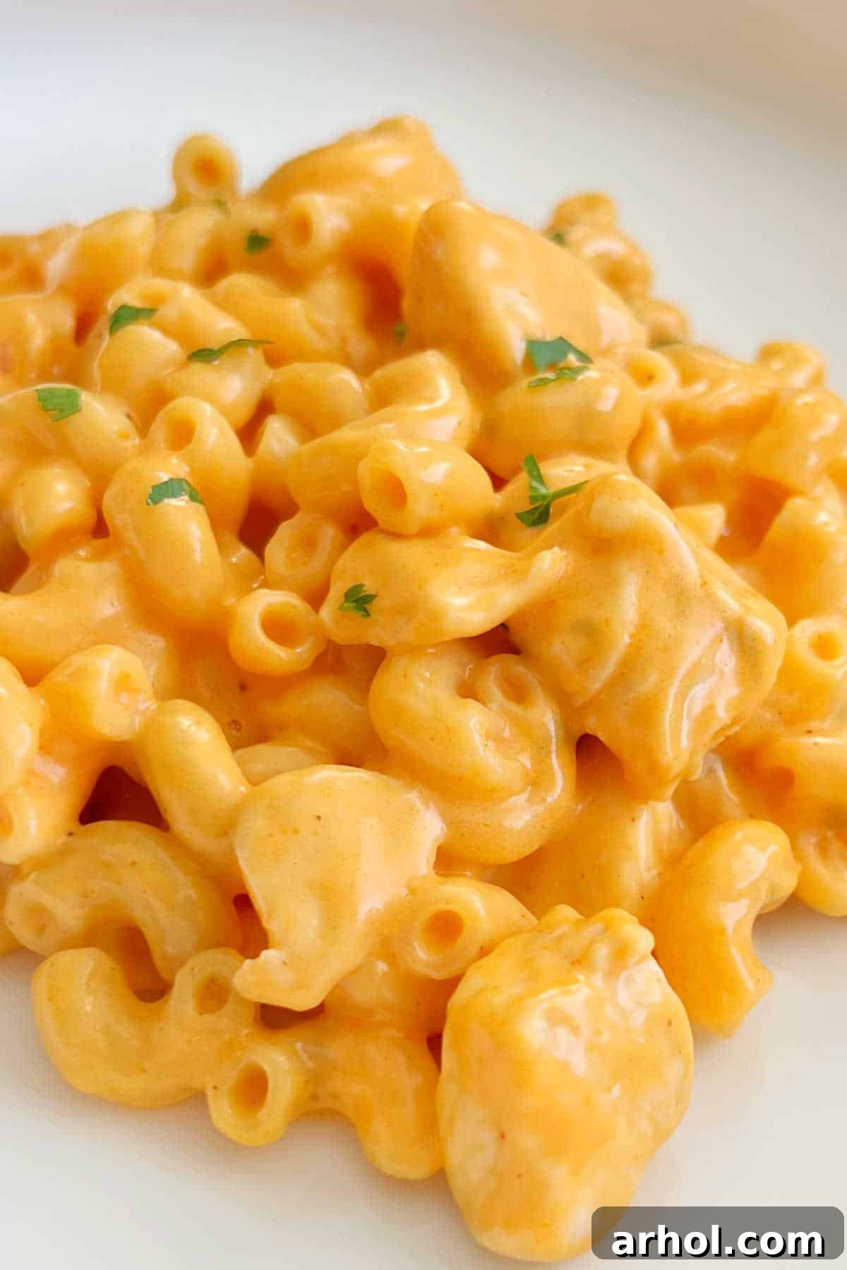 A plate of freshly prepared Buffalo Chicken Mac and Cheese, garnished with parsley, ready to be enjoyed.