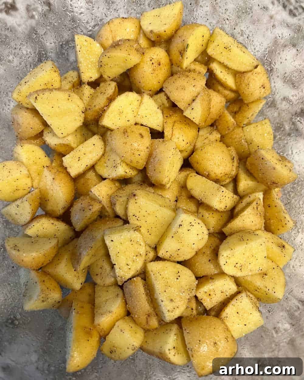 Sizzling Spuds The Blackstone Way 4 Seasoned and oiled potatoes in a mixing bowl, ready for the Blackstone griddle. Original photo.
