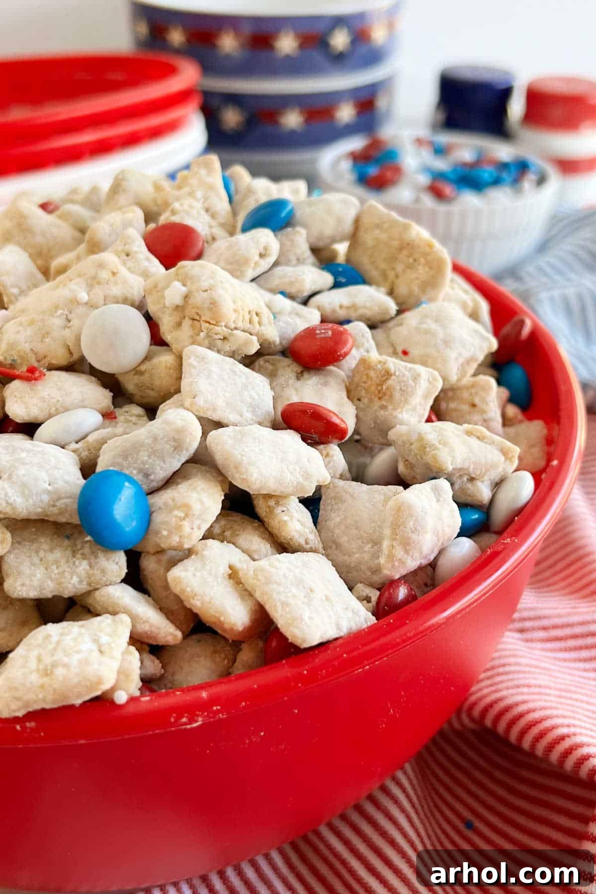 Star-Spangled Snack Mix 2 A vibrant bowl of Red White and Blue Puppy Chow (Muddy Buddies) with festive patriotic table decorations, perfect for the 4th of July.