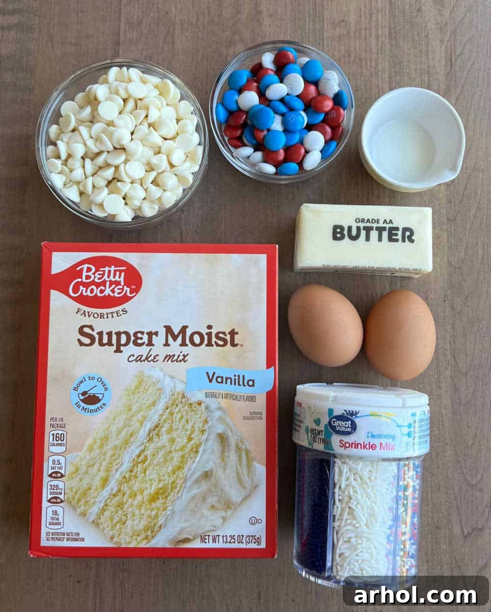 Key ingredients for easy 4th of July cookies: white cake mix, rich white chocolate chips, colorful red, white, and blue M&M's, fresh milk, melted butter, and large eggs.