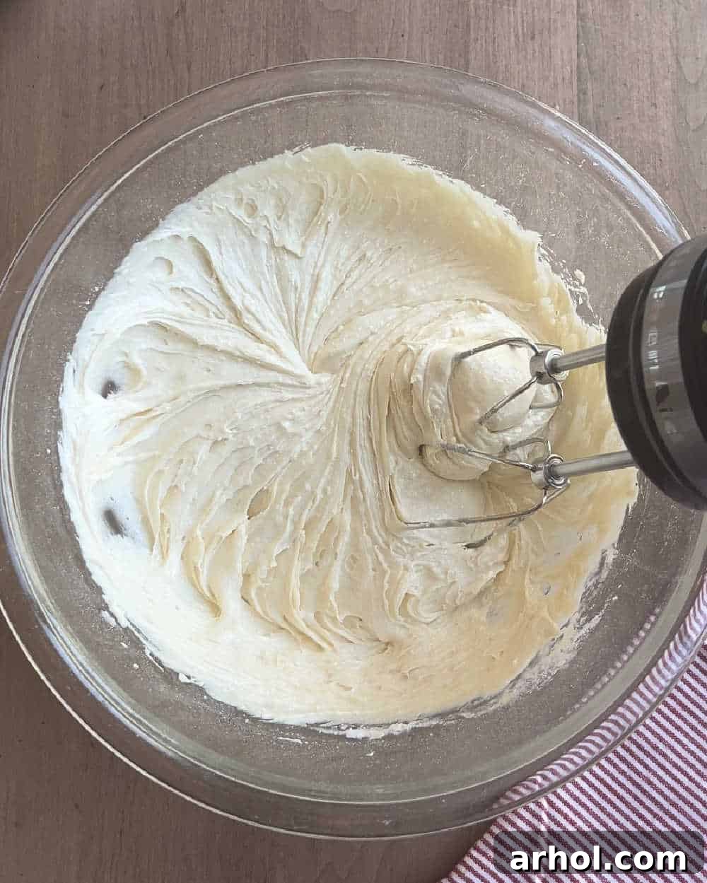 Mixing the easy 4th of July cookie dough ingredients in a large bowl with a hand mixer, ensuring a smooth, well-combined batter.