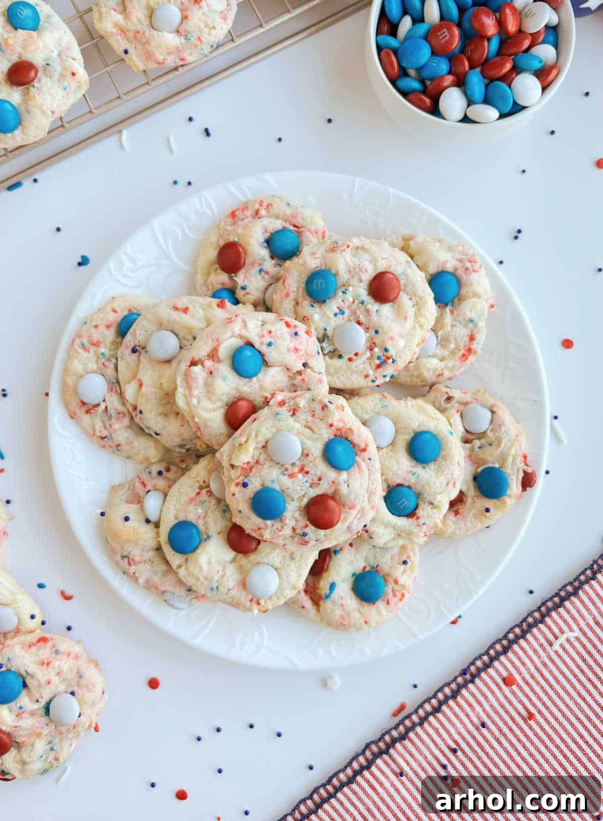Freshly baked red, white, and blue cake mix cookies, adorned with M&M's, beautifully arranged on a serving plate for a festive 4th of July dessert.